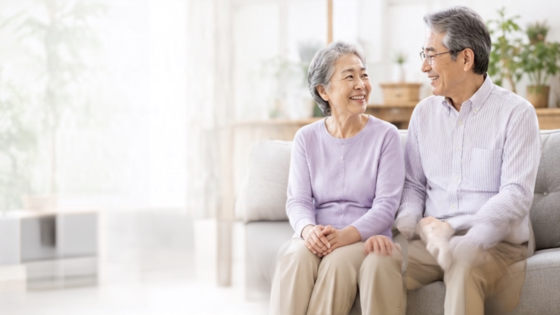 明るいリビングで笑顔のシニア夫婦が相談するイメージ